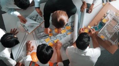 Yetenekli mühendis ekibinin proje planına bakarken konuştuğu en üst seviye görüntü. Birlikte çalışan ve mühendislik inşaatı için plan yapan bir grup akıllı iç mimar. Hizalama.