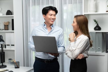 Gülümseyen Asyalı iş arkadaşları modern ofiste dizüstü bilgisayar pazarlama projesi hakkında konuşurken. Yeni sosyal medya kanalında başarılı müşteri ihtiyaçları analiz ediliyor. İnfobahn.