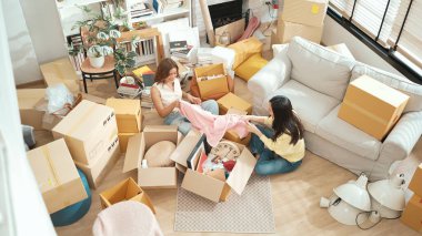 Kutuları açan ve mobilyaları toplayan mutlu arkadaş manzarası. Karton kutuyla çevrili oturma odasında konuşurken yeni daireye taşınan çekici bir genç. Malikane. Myrmidon.