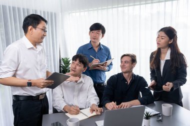 Bir grup farklı ofis çalışanı şirket ofis odasında stratejik iş pazarlama planlamasında birlikte çalışıyor. İş yeri konseptinde pozitif takım çalışması. Tedbirli