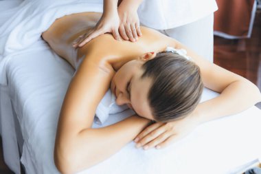 Kafkasyalı kadın müşteri stres önleyici spa masajının keyfini çıkarıyor ve lüks otel ya da oteldeki gündüz açık ortam güzellik salonunda güzellik teniyle eğleniyor. Sessiz.