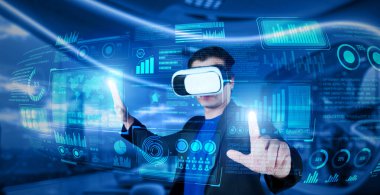 VR gözlüklü bir proje yöneticisi mali tabloyu ve ofisteki parlak mavi ışığı gösteriyor. Yetenekli iş adamı artırılmış gerçeklikten elde edilen verileri kullanarak pazarlama stratejisini kontrol edip planlıyor. Yaratıcılık.