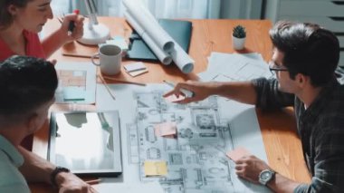Ev inşaatını planlamak için birlikte çalışan mimar mühendis ekibinin üst görüşü. Profesyonel iş konuşmaları ve toplantı odasında inşaat veya ev inşaatı hakkında tartışmalar. Sempozyum.