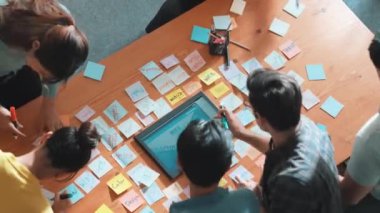 Mobil telefon arayüzü ile ilgili yetenekli programcı beyin fırtınası fikrinin üst görüntüsü kablo prototipi kullanarak uygulama geliştirme aşamasında. Yapışkan notlarla birlikte web tasarımcısı planlama yapıyor. Sempozyum.