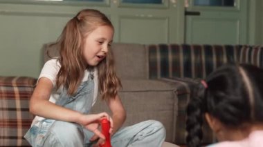 İlkokulda oyun odasında otururken farklı çocuklarla oyuncak oynayan mutlu bir kız. Farklı çocuklu plastik araba mankeni tutan yetenekli bir öğrenci. Yaratıcı aktivite eğitimi konsepti. Etkinlik.