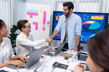 Analist ekip lideri, iş zekası ya da BI gösterge paneli ile FIntech yazılım gücünü kullanarak başarılı veri analizi toplantısından sonra iş arkadaşıyla tokalaştı. Tedbirli