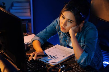 Bitkin düşmüş, genç, güzel Asyalı yaratıcı hisler, bilgisayardan e-posta beklemek için bekliyor. Projenin yaratıcısı sosyal medyanın veri tablosunu gece vakti neon ofiste karşılaştırıyoruz. Taktik.