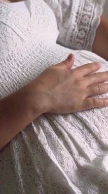 Hamile bir kadın çocuğuna bakarken kendini mutlu hissediyor. Hamile karnında bebek taşıyan hamile bir anne. Doğum öncesi bakım ve kadın hamileliği konsepti.