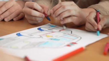 Çeşitli öğrenci ve öğretmenlerin el yazısı ya da çizimi. Akıl hocası ve çok kültürlü çocuklar renkli kalemler, kalemler ve pastel boyalarla birlikte faaliyet gösteriyorlar. Yaratıcılık atölyesi. Etkinlik.