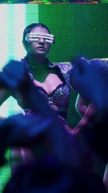 Bir grup insan disko gece kulübünde DJ 'in sahnede çaldığı müzikle dans ediyor. Yeni yıl partisi ve gece hayatı konsepti .