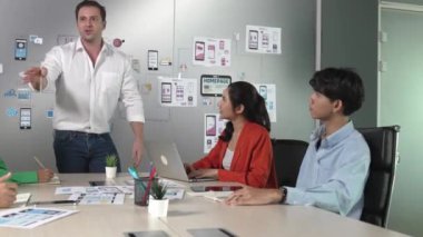 Bir grup profesyonel iş adamı Ux ve Ui tasarımı hakkında konuşuyor. İşbirlikçi çeşitli iş adamları pazarlama planı hakkında beyin fırtınası yapıyor. Birlikte çalışan iş adamları. Yönlendirici.