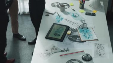 Gündelik kıyafet giymiş profesyonel mühendis ekibi masada teçhizatlı, hesap makineli, yapışkan notlu türbin motor yapısı hakkında konuşuyor. Bir grup teknisyen toplantıda el sıkışıyor. Hizalama.