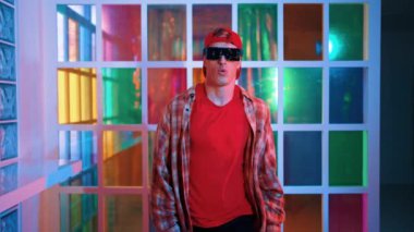 Serbest stil tişört giyerken sokak müziği çalan mutlu hipster. Gece kulübünde neon ışıkla dururken çekici break dansçı dans ve hareketli hareketler yapıyor. Mutluluk.
