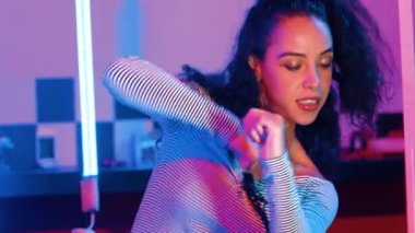 Stüdyoda mor ışıkla sokak dansı yapan İspanyol sokak dansçılarına yakın çekim. Profesyonel sanatçı şık kumaşla enerjik bir hareket sergiler. Çılgın, komik. Yarı vücut. Mutluluk.