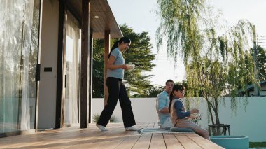 Family of father, mother and daughter gather at terrace view garden outside house. Parent use outdoor activity to communicate young generation about environment care cross generation gap. Divergence. clipart