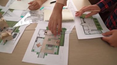 Akıllı mimar ya da akıllı mühendisin ölçüm aracı ve kalem el kullanarak mimari ofisindeki inşaat isabet planı üzerine detaylı bir yazı yazışının videosu. Eline odaklan. - Yakın çekim. Tanımlama.