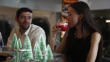 Grup arkadaşı ya da çift, Noel temalı karışık punç kokteyli eşliğinde süslü Noel ağacında süslenmiş şeker kamışı tatmak için özel zamanlarda ön taraftaki lüks tezgah barında konuşuyor. Vinosity.
