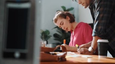 Akıllı proje yöneticisi logo tasarımını seçen iş adamıyla birlikte çalışıyor. Profesyonel iş adamları renk paletlerine bakarken pazarlama stratejisini tartışıyor ve planlıyorlar. Sempozyum.