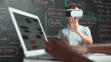 Kara tahtadaki Afrikalı öğrenci el kodlaması ya da programlama sisteminin web geliştirme planıyla kapatılması. Bu arada genç bir kız da mühendislik dersiyle kara tahtada oynuyor. Yenilik. Öğretim