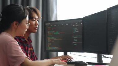 Yavaş çekim arkası yazılım geliştirici mühendisi bilgisayar programlama için birlikte çalışarak hata ayıklama kodunu çözüyor, ofiste monitörde karmaşık algoritmaları çözüyor. Filizlenen