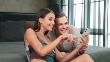 Genç çift, online ödeme uygulaması ve dijital cüzdanı kullanarak kredi kartıyla ödeme yaptıktan sonra mutlu ve heyecanlı hissediyorlar. Mobil internet üzerinden alışveriş ve modern alımlar. Düzenle