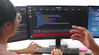 Yavaş çekim arkası yazılım geliştirici mühendisi bilgisayar programlama için birlikte çalışarak hata ayıklama kodunu çözüyor, ofiste monitörde karmaşık algoritmaları çözüyor. Filizlenen