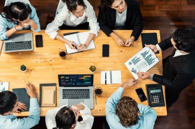 Panorama üst düzey iş analist grubu toplantı masasındaki finansal veri raporunu analiz ediyor. İş zekası analizine göre çizelge ve grafik paneli. Çok titiz.