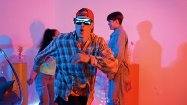 İspanyol hipster renkli kıyafetler giyer ve serbest stil müziğe el sallar. Profesyonel break dansçı neon ışıklarıyla ve modern stüdyo arkadaşlarıyla coşkuyla dans ediyor. Mutluluk.