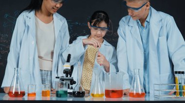 Zeki kız deney yapmak için heyecanlanan çeşitli öğrenciler iken beher kabına renkli solüsyon döker. Profesyonel bilim adamı kimyasal teoriyle kara tahtada deney yapmaya hazırlanıyor. Öğretim.