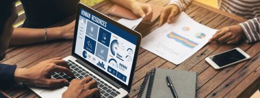 Human resources management software on computer screen helping human resources employee to manage recruitment, payroll, staff searching and KPI evaluation snugly