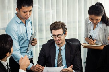 Modern ofis ortamında çalışan çeşitli etnik gruplardan çeşitli iş adamları. Üretken ve çok ırklı ofis çalışanları stratejik ticari pazarlama konusunda tartışmaya giriştiler. Çok titiz.