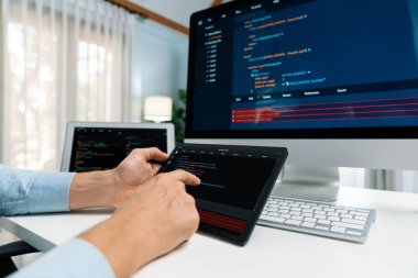 IT geliştiricisi, tablet üzerindeki yazılım geliştirme bilgisini pc ve laptop ekranıyla karşılaştırarak güncelleme sürüm genel sisteminde yeni bir kod programıyla nokta nokta seçiyor. Bireysel.