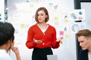 Profesyonel çekici kadın lider, modern iş toplantı odasında beyin fırtınası zihin haritalama istatistikleri ve renkli yapışkan notlar kullanarak yaratıcı pazarlama planını sunuyor. Tertemiz..