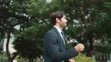 Keyifle dans eden yetenekli beyaz iş adamı soğukkanlılığını koru ve şehir merkezinde yürümeye devam et. Profesyonel menajer terfi ile ilgili iyi haberleri kutlamak için dans ediyor. Sevinçli..