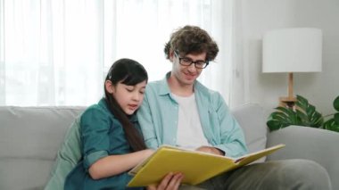 Beyaz bir baba ve tatlı bir kız kanepede otururken masal kitabı okuyorlar. Mutlu bir baba, sevimli bir Amerikan çocuğuna, birlikte zaman geçirirken hayal gücünün gelişmesi için hikaye anlatıyor. Pedagoji.