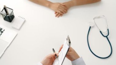 Klinikteki ya da hastane ofisindeki doktor randevusuna katılan hasta, tıbbi tedavi seçeneklerini tartışıyor ve muayene sonuçlarını ya da hastalıkla ilgili tıbbi kayıtları açıklıyor. Ağır çekim. Katı.