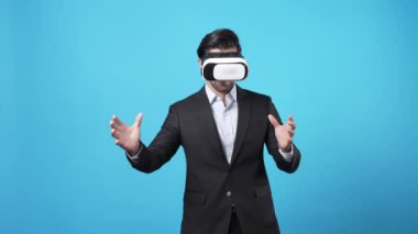 Mali verileri kontrol ederken ve mavi arka planda dururken hologram tutan yetenekli bir işadamı. Pazarlama stratejisi planlarken istatistik grafiklerine bakan yetenekli bir yatırımcı. Aygıt.