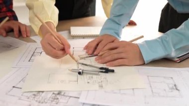 Mimarlar veya akıllı mühendislerin videosu mimari ofisindeki inşaat doğruluğu için taslak üzerinde ölçüm aracı, bölücü ve kalem el yazısı detaylarını kullanır. Eline odaklan. - Yakın çekim. Tanımlama.