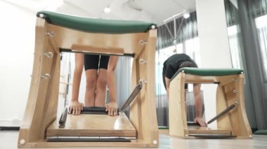 Müşteriler pilates antrenmanı sırasında ayakta gerinme egzersizi yapıyorlar. Esnekliği artırmak için. Spor salonunda bacak dayanıklılığı. Çekici grup esniyor ve eğiliyor. Alışkanlık.