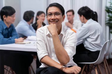 Mühendis ekip lideri portresi çeşitli inşaat mühendisi ve müvekkil gruplarıyla birlikte mimari proje üzerinde çalışıyor, inşaat planını gözden geçiriyor ve toplantı masasında proje oluşturuyorlar. Tedbirli