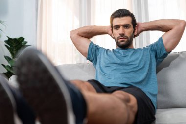 Atletik vücut ve aktif sporcu, sağlıklı vücut çalışma yaşam tarzı konsepti olarak neşeli ev egzersizlerinde kas kazanma egzersizi yapmak için mobilyaları kullanıyor..