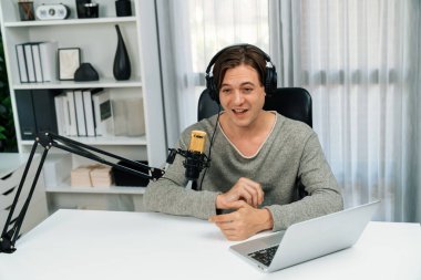 Sunucu kanalı, gülümseyen akıllı yayıncı kaydı, senaryosu ve akıllı telefonuyla sosyal medyada sohbet programı, kulaklık takarak modern ev stüdyosundaki video flamalarını kaydediyor. Bireysel.