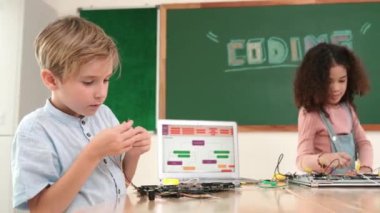 Dizüstü bilgisayar ekranında çalışan çeşitli öğrenci kodlama mühendisliği komut yazılımı ve yapay zeka programlaması yapıyor. Amerikalı kız, erkek makine tamir ederken ekipmanları teftiş ediyor. Pedagoji.