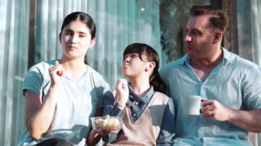 Güzel bir evlilik çifti ve kızı açık terasta yemekli piknik yapıyorlar. Açık hava aktivitelerini kullanan aile, çocuk ve güçlü aile bağı veya ilişkisinin gelişmesini desteklemek için sevgiyi gösterir. Uyumsuzluk.