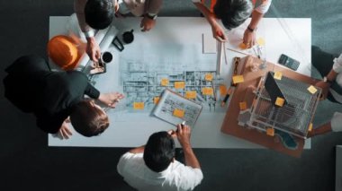 Becerikli mühendis ekibinin ev inşaatından bahsedişinin en alt görüntüsü. Mimar ya da tasarımcı grubunun planlar hakkında beyin fırtınası yapmak için tartışan ve yazan hava görüşü. Hizalama.