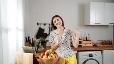 Enerjik beyaz anne kahvaltı için salata pişirirken ve yemek pişirirken elinde kepçeyle şarkı söylüyor. Sağlıklı yemek yapmaya hazırlanırken müziğe yönelen mutlu ev sahibi. Pedagoji.