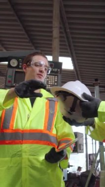 Fabrika işçisi iş arkadaşını güvenlik konusunda uyardı ve ona sert şapka verdi. Önce yaralanma önleme ve güvenlik kavramı .