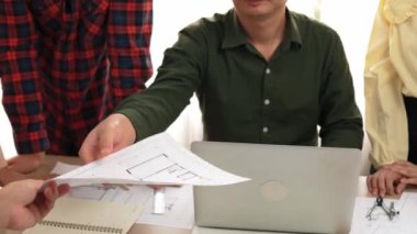 Akıllı mimar ve güvenlik mühendisi, mimari belge, ölçüm araçları ve ahşap blokların modern ofiste etrafa saçıldığı masa planlarını tartışıyor. - Yakın çekim. Tanımlama.