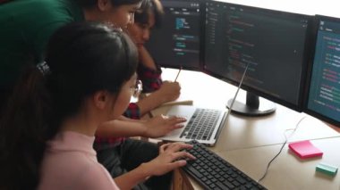 Yavaş çekim arkası yazılım geliştirici mühendisi bilgisayar programlama için birlikte çalışarak hata ayıklama kodunu çözüyor, ofiste monitörde karmaşık algoritmaları çözüyor. Filizlenen