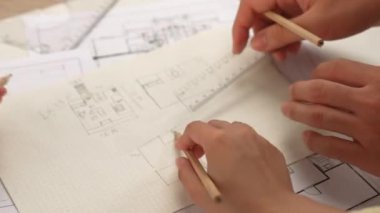 Mimari ekipmanlarla toplantı masasında ev tasarımı üzerine profesyonel mühendis ekibi tartışması ve modern ofiste bina planı dağılımı. Eline odaklan. - Yakın çekim. Tanımlama.